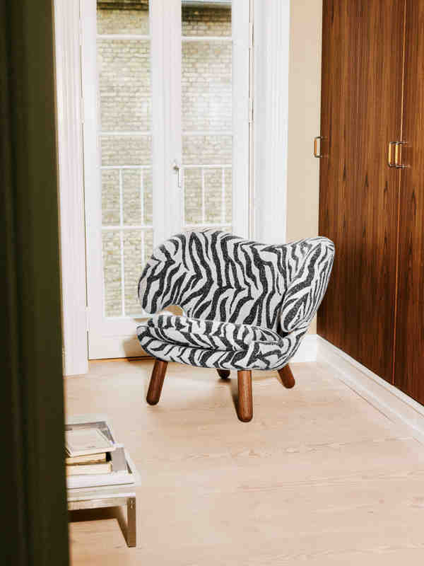 The Pelican Chair with legs in walnut and upholstery in 'Sahco' textile in the color '0152'.