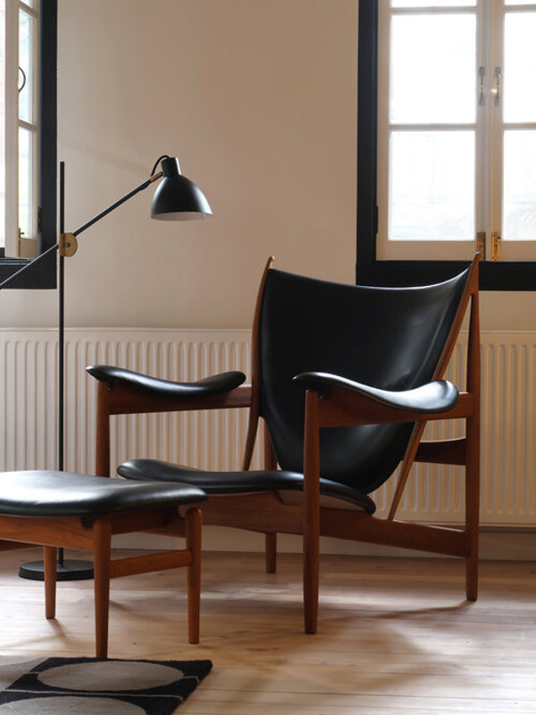 The Chieftain Footstool in walnut with 'Elegance' upholstery in the colour 'Black'.