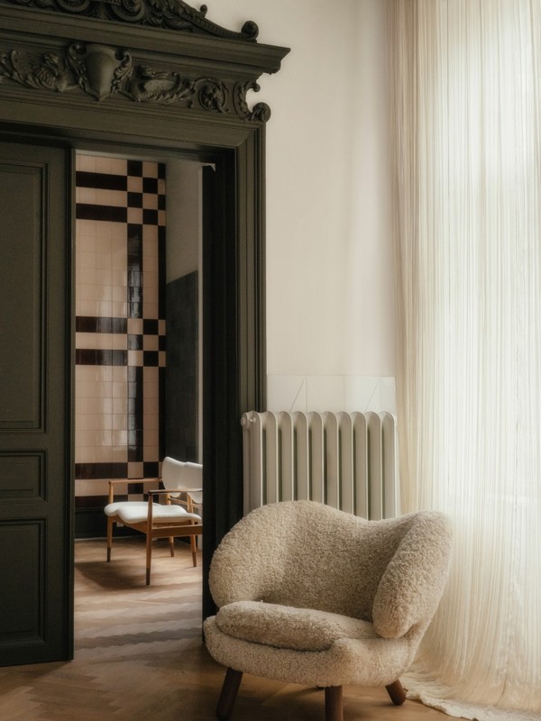 The Pelican Chair with legs in walnut and upholstery in sheepskin in the color 'Moonlight'.