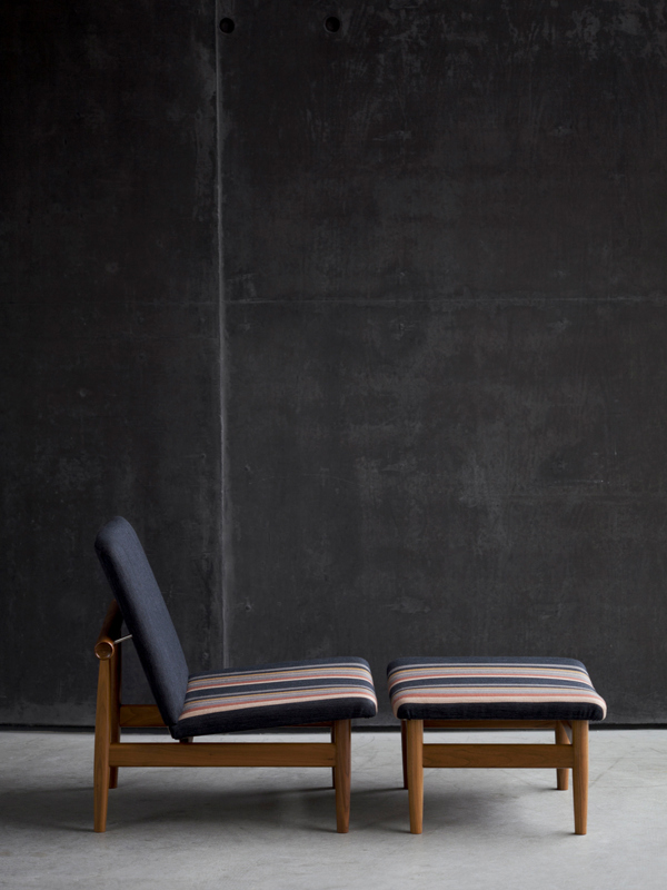 The Japan Chair and Footstool with walnut frame and 'Als' upholstery in the colour '18-451'.