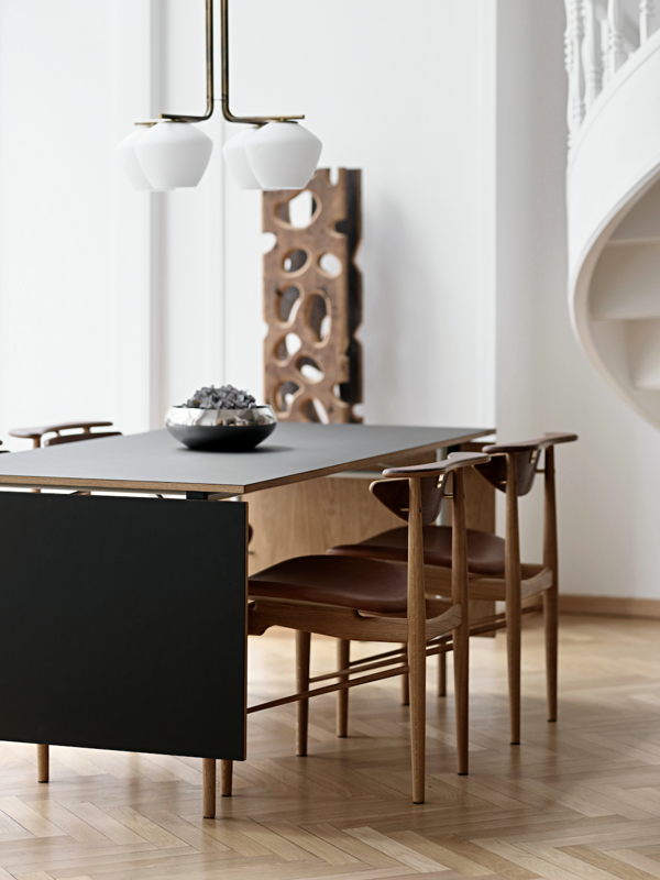 The Nyhavn Dining Table with oak (dark oil) edges and feet, light blue steel legs and black linoleum surface.
