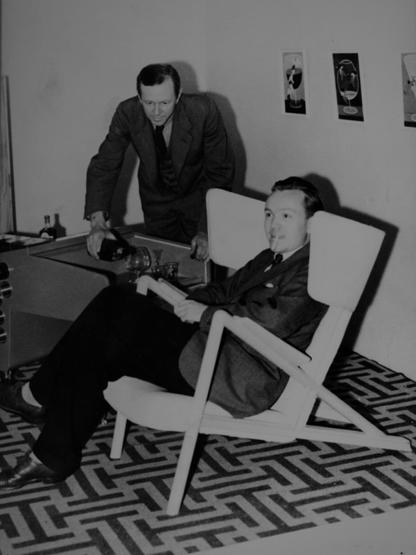 Finn Juhl photographed at his and Niels Vodder's stand at the Cabinetmakers' Guild Exhibition in 1938. 