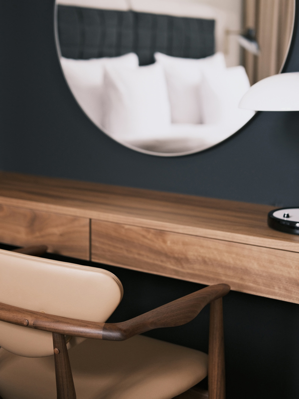 Details of the 109 Chair in walnut with ‘Flux’ leather upholstery in the colour ‘Light Brown’.